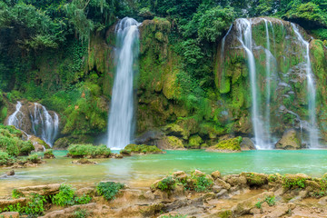 Fototapeta na wymiar Amazing Ban Gioc waterfall flow down fluted in Cao Bang province, Vietnam. Ban Gioc waterfall is one of the top 10 waterfalls in the world along Vietnam and China border