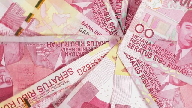 Top view of Indonesian Rupiah money spinning on the table in the studio