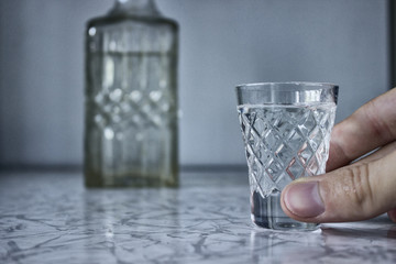 Alcoholism, arm is holding glass with vodka
