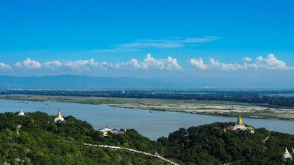 Obraz premium High angle view of multiple temples and pagodas on the mountains with Irrawaddy river in the background from sagaing hill, Sagaing region of Myanmar