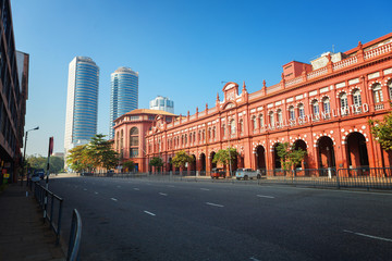 Colombo, Sri Lanka - 11 February 2017: The red building of Cargills and Miller in York Street with the skyscrapers of World Trade center - obrazy, fototapety, plakaty