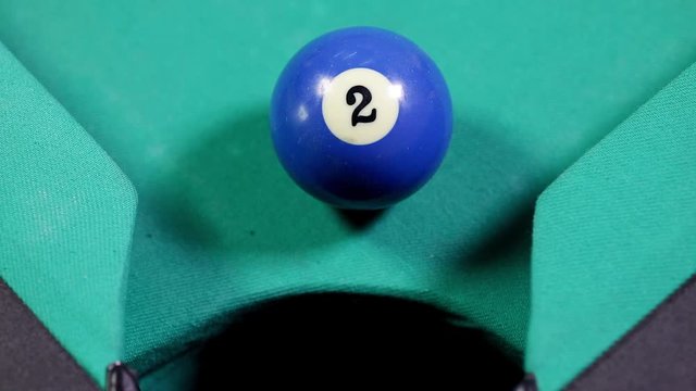 Close up of a billiard ball number four with purple color, falling into the billiard table hole