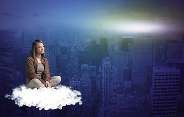 Fototapeta na wymiar Woman sitting on cloud above the city