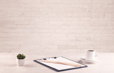 Office desk closeup with white brick wall