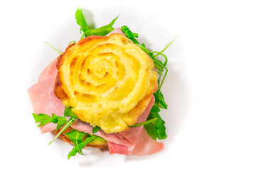 Stuffed frittata, cooked in the microwave oven, shaped like a rose, with rocket salad, speck, cooked ham (ingredients: eggs, cream, salt, emmentaler) on a white background