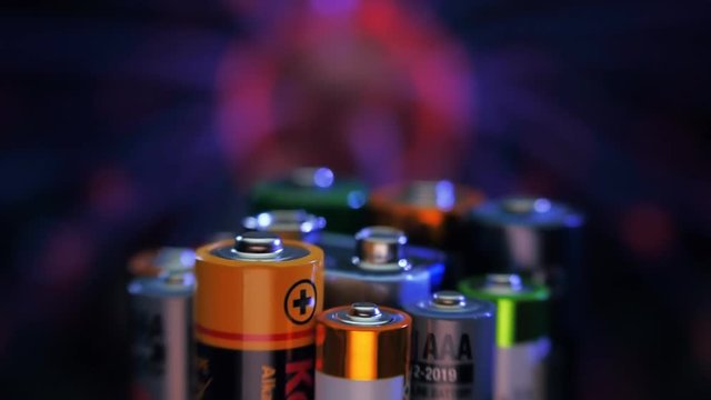 Alkaline batteries stand against the background of the plasma ball. Macro. Closeup. Shallow depth of field
