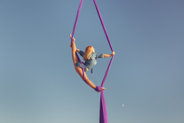 Acrobat in the sky on the canvas shows the show, she's an aerial gymnast.
