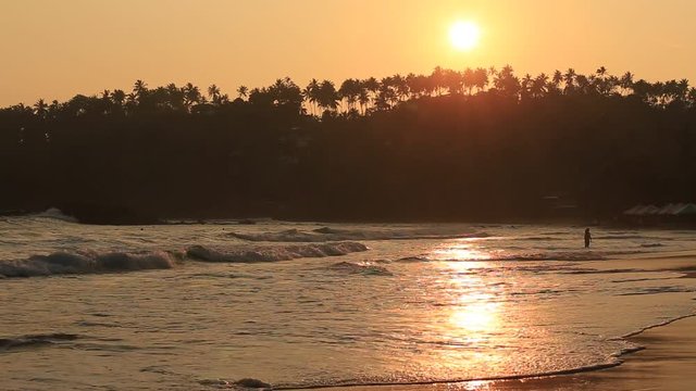 Tropical sand beach and sea water wave at Mirissa during sunset, Sri Lanka