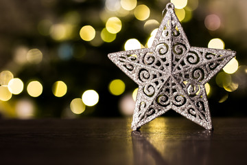 Christmas tree star decoration with lights in background