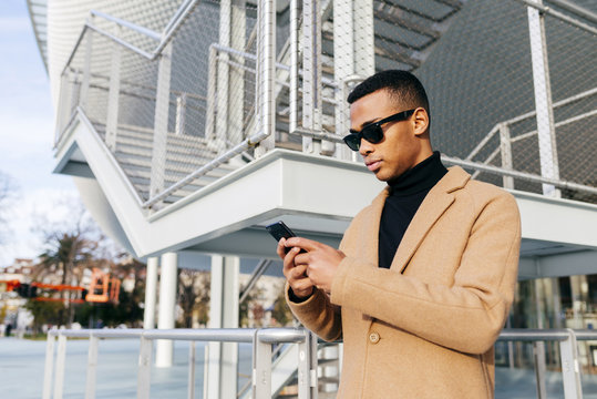 Stylish black man browsing smartphone