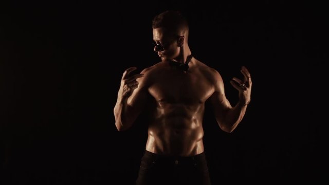 Sexy man dancing on black background