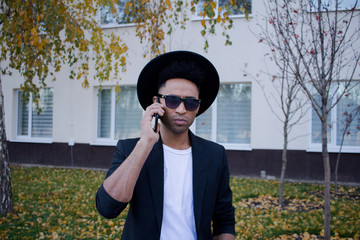 young happy male in black suit and black hat, concept of modern buisinessman  