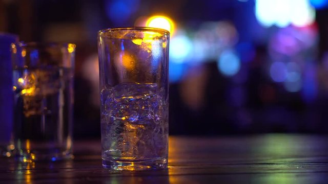 Empty alcohol glass with disco light in nightclub