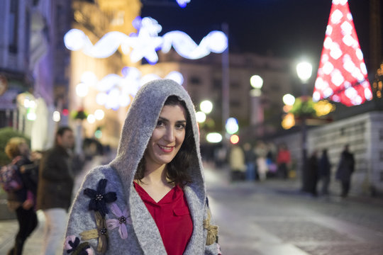 Woman looking at camera in night portrait with christmas lights background