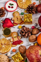 Many new year attributes and free space for your text, congratulations. Fruits, sweets, nuts and decorations for a Christmas tree. Beautiful festive winter layout.