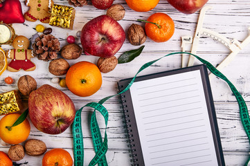 Plan to lose weight, go on a diet in the new year. Healthy sweets for weight loss in the new year. Traditional set of Christmas fruits, biscuits and nuts. Accessories for measuring weight, parameters.