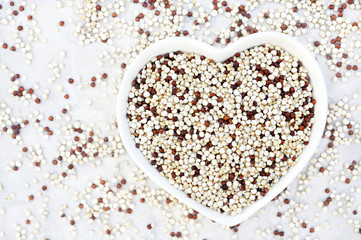 Quinoa in heart-shaped bowl, gluten free ancient grain for healthy diet