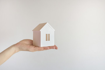 The model of the White House costs on a female hand on a white background