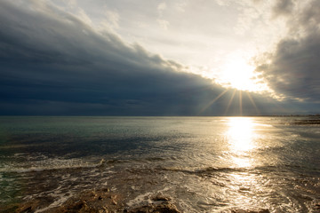 The calm sea in a very cloudy sunset