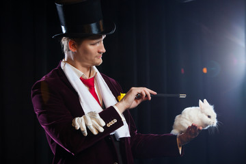 Magician with rabbit, Juggler man, Funny person, Black magic, Illusion on a black background