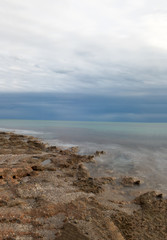 The calm sea in a very cloudy sunset