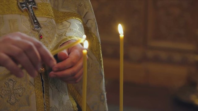 The Sacrament of Baptism in the Orthodox Church. Close-up of a priest lighting candles in a font
