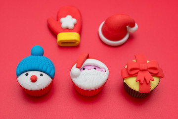 christmas decorative doll of santa claus and snowman and present box and hat and glove on red background