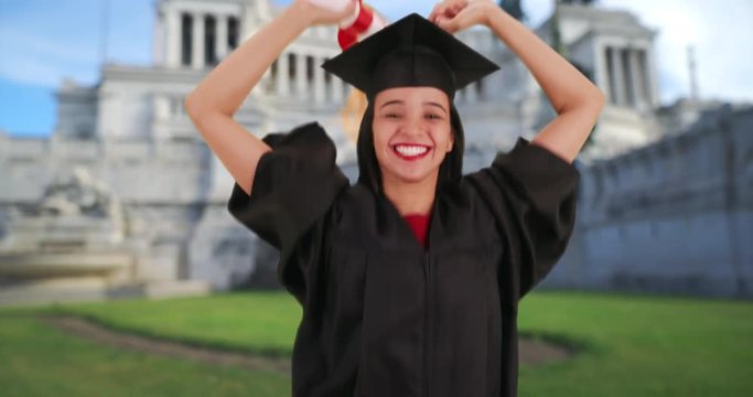 Graduating Hispanic girl happily accepts her college diploma in Rome. Celebrating Latina triumphs after receiving her diploma at her graduation in front of the Piazza Venezia. 4k