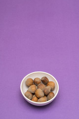 hazelnuts in a bowl on a colored background	
