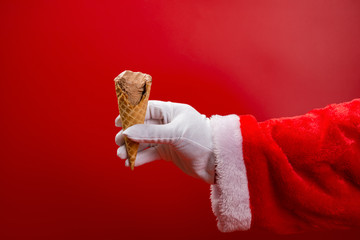 santa claus holding an ice cream cone with some bites on red