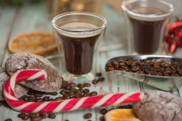 Black coffee in glass cups with christmas decoration and candies. Close view on candy