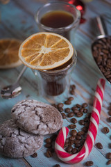 Black coffee in glass cups with christmas decoration and candies. Cold toned composition