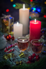 A couple of burning candles and glass cups of tea. Still life composition with christmass decoration on rustic background 2