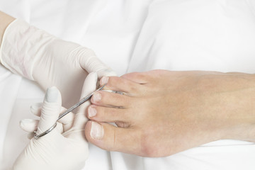 Female foot in the process of pedicure procedure in a beauty salon close-up.
