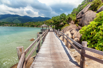 Fototapeta premium Long wooden bridge pavilion in beautiful tropical island beach sunset - Koh Phangan, Thailand, Lila beach