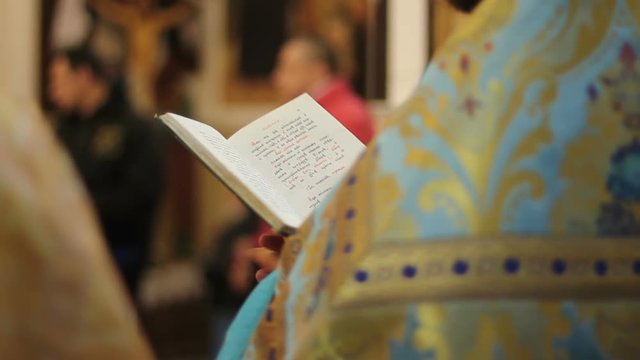 Orthodox Church clergyman reading psalm book, conducting festive service, prayer