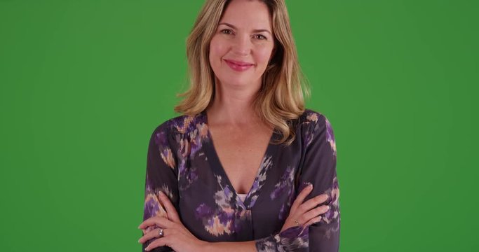 Woman in blouse smiling at camera on green screen. On green screen to be keyed or composited.