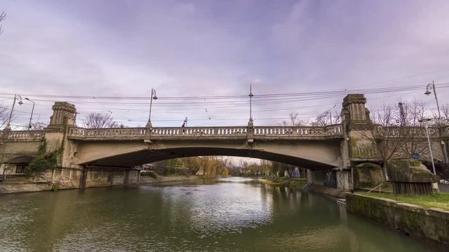 timelapse of Bega river with arch bridge at sunset
