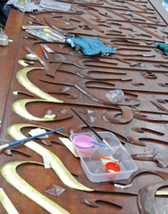 Arabic calligraphy made from timber coated with gold leaf in the making.  