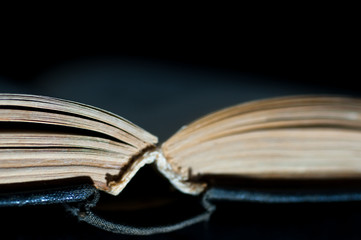 Old, yellow pages, opened book isolated on black background.