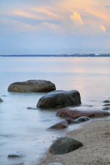 Obrazy na Szkle  Wieczorem woda morska z brzegu i kamienie na plaży Orłowo w Gdyni, Trójmiasto, Polska