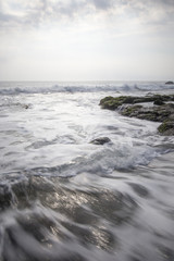 Naklejka na ściany i meble waves crashing on the rocks and splash at Bali Beach, Indonesia