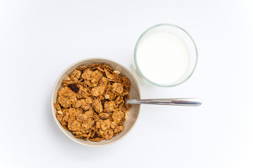 Glass of milk and bowl of brown cereals