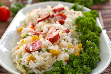 Rice with sausage and vegetables in ceramic bowl, closeup
