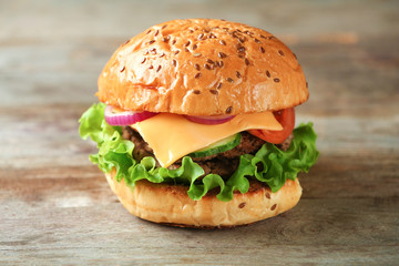 Tasty burger on wooden background