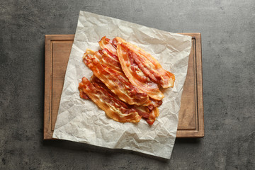 Board with cooked bacon rashers on table