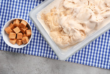 Caramel candies and delicious ice cream on table