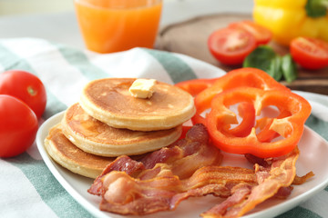 Tasty breakfast with pancakes and bacon on plate