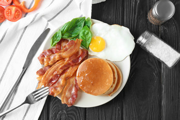 Tasty breakfast with pancakes and bacon on plate