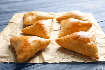 Delicious baked samosas on table